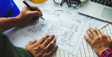Two electrical engineers assessing blueprints